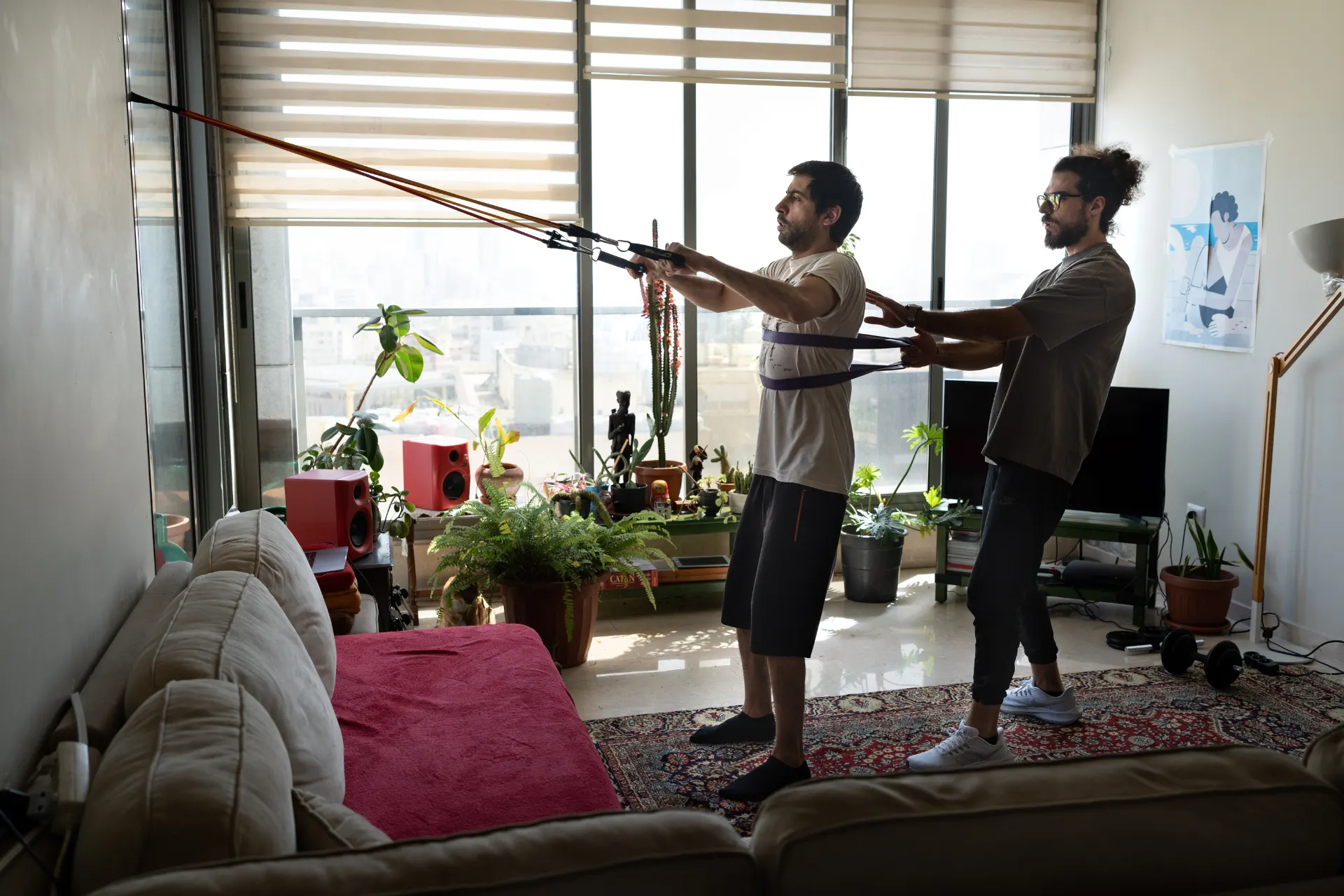 Samer coaching a client with resistance bands
